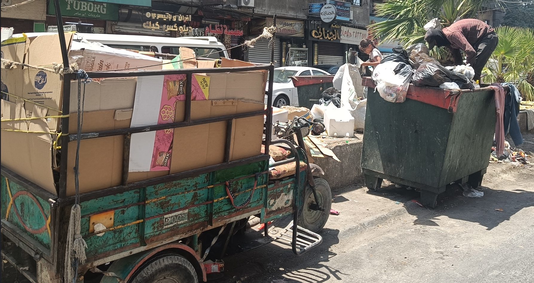 A waste collector gathering cardboard in Jaramana